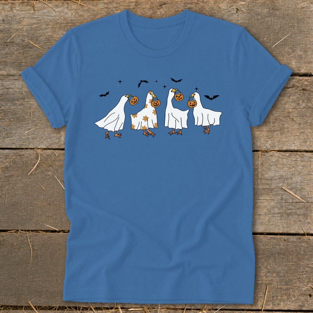 Four geese in ghost costumes carrying pumpkins with bats in the background.