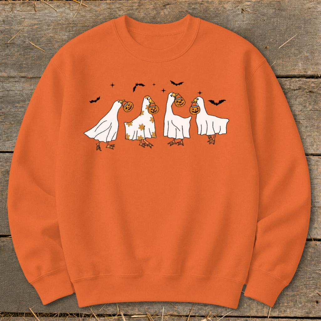 Orange sweatshirt with cartoon geese in ghost costumes holding pumpkins.
