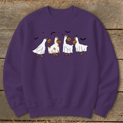 Purple sweatshirt with cartoon ghosts carrying pumpkins and bats for Halloween.