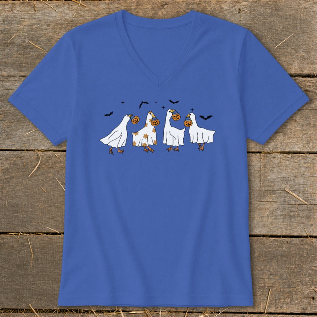 Four cartoon geese in ghost costumes hold pumpkins, with bats flying above.