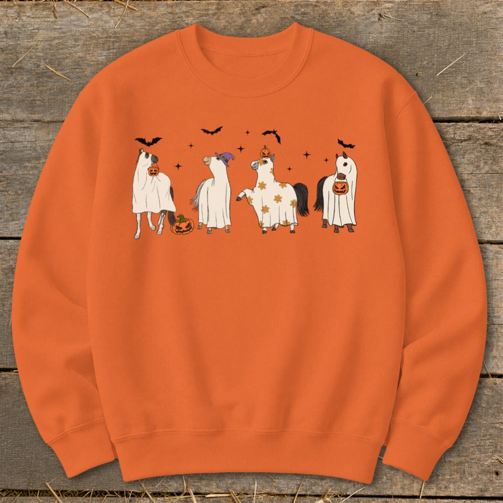 Four horses in ghost costumes with pumpkins and bats on an orange sweatshirt.
