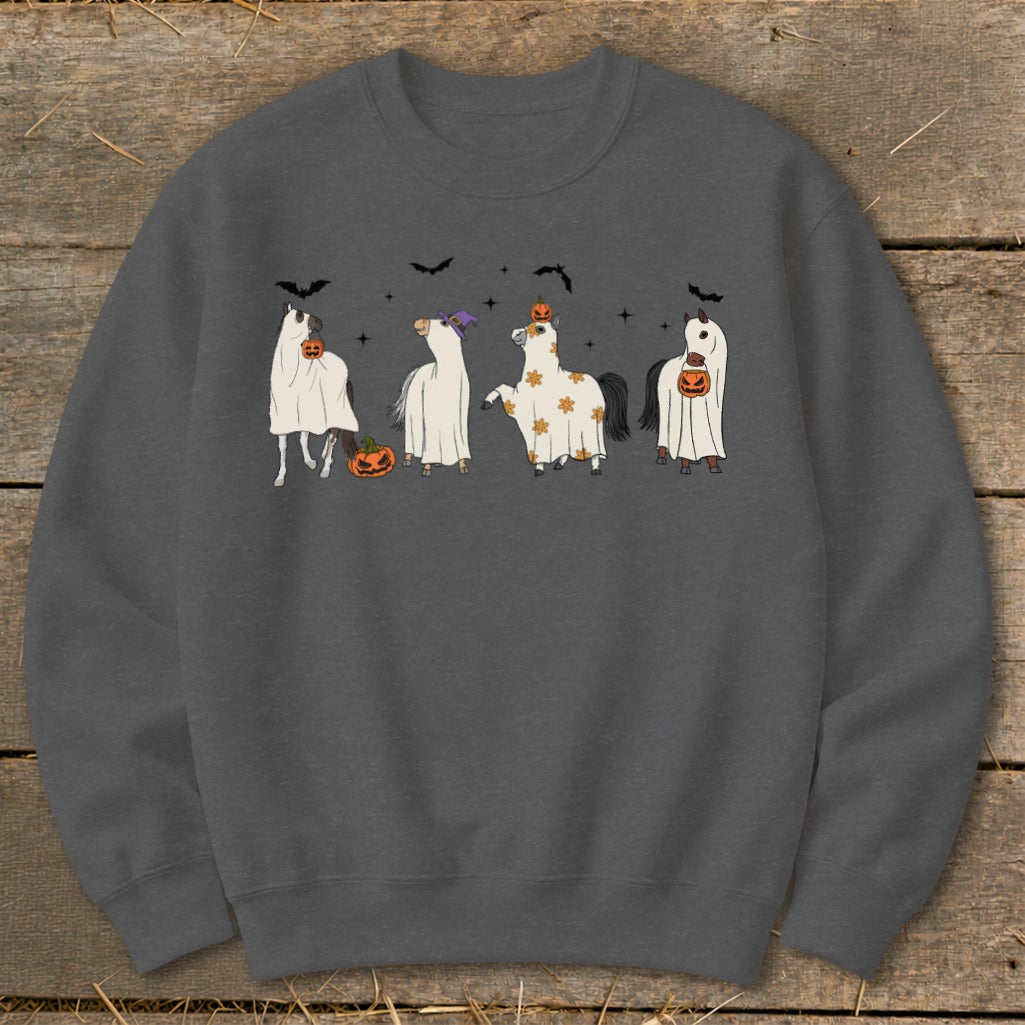 Four horses in Halloween costumes with pumpkins and bats.