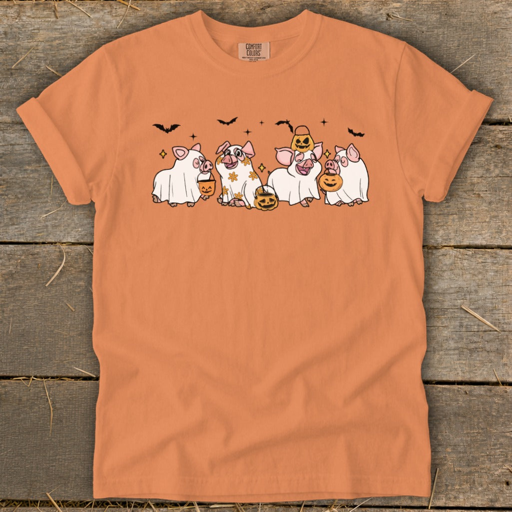 Orange t-shirt with four pigs dressed as ghosts holding pumpkins.