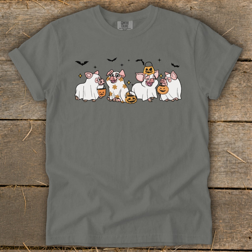 Five pigs in ghost costumes with pumpkins and bats, celebrating Halloween.