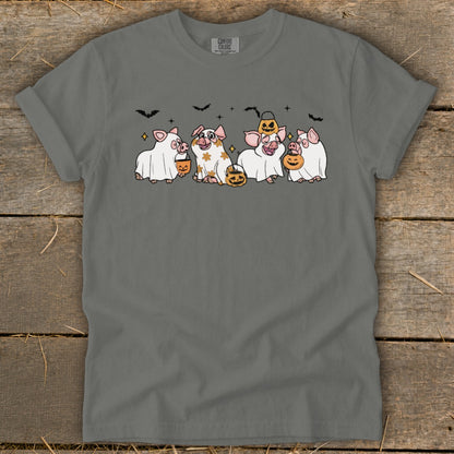 Five pigs in ghost costumes with pumpkins and bats, celebrating Halloween.
