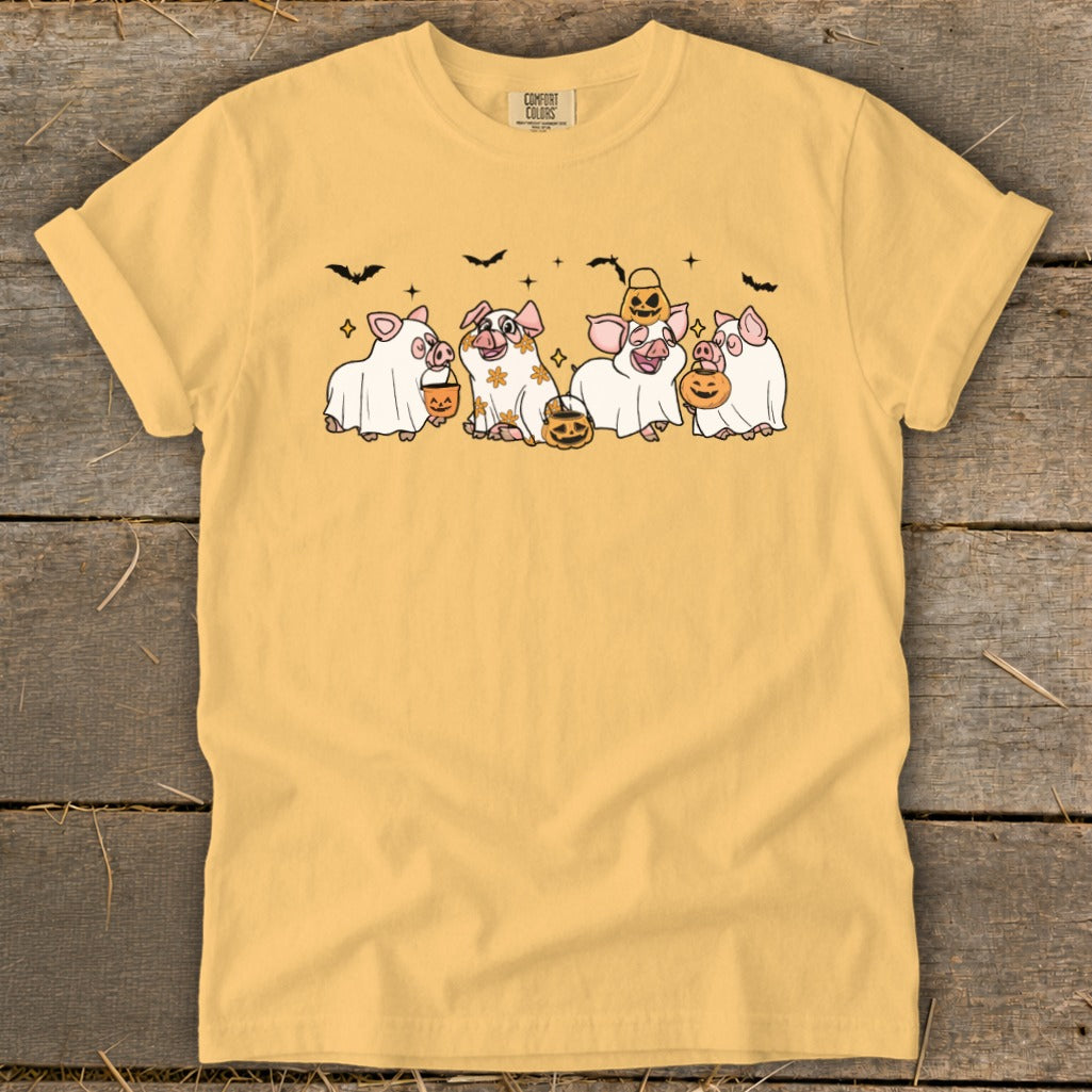 Yellow t-shirt with cartoon pigs dressed as ghosts holding pumpkins and candy buckets.