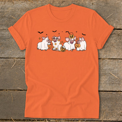 Five pigs in ghost costumes with pumpkins and bats on an orange t-shirt.