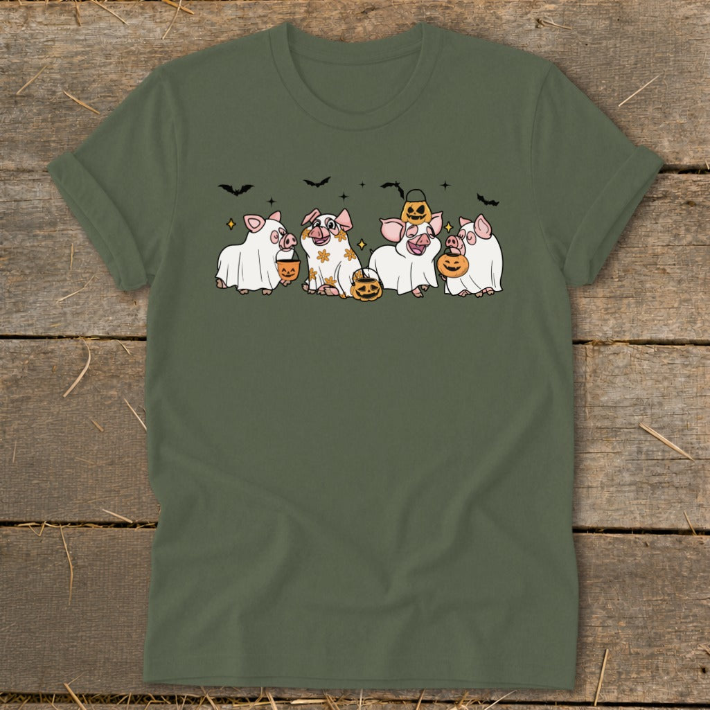Five pigs in ghost costumes hold pumpkins with bats above them on a green t-shirt.