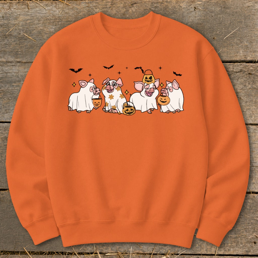 Orange sweatshirt with cartoon pigs dressed as ghosts holding pumpkins and bats.