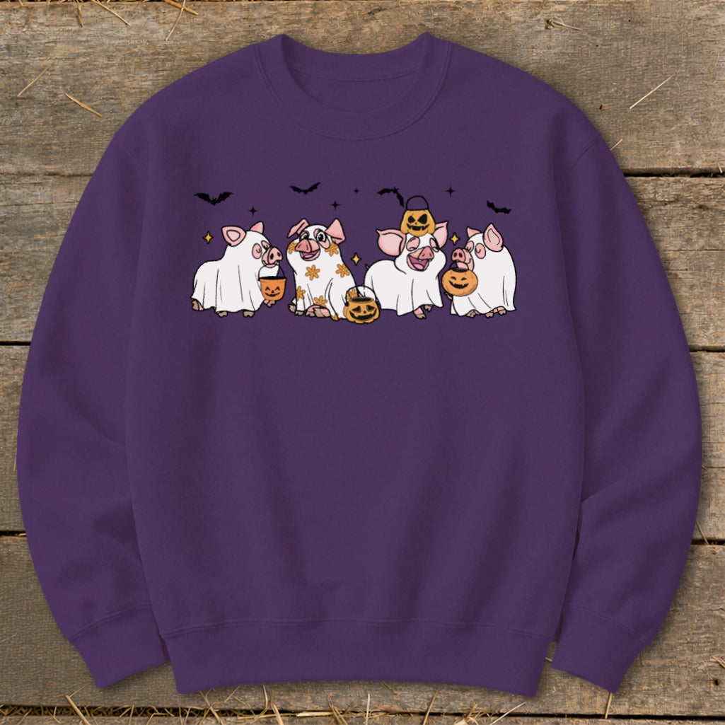 Purple sweatshirt with cartoon pigs in ghost costumes and pumpkins.