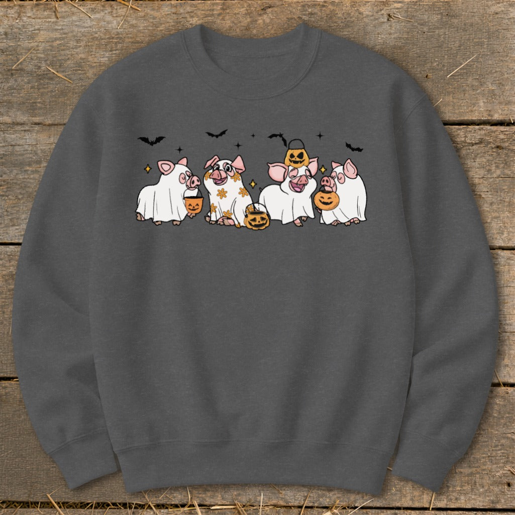 Five pigs in Halloween costumes with candy buckets and pumpkins, against a dark background.