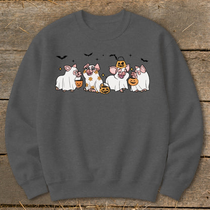 Five pigs in Halloween costumes with candy buckets and pumpkins, against a dark background.