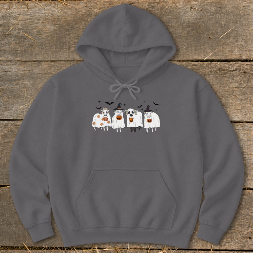 Four cartoon cows dressed as ghosts with pumpkins and bats.