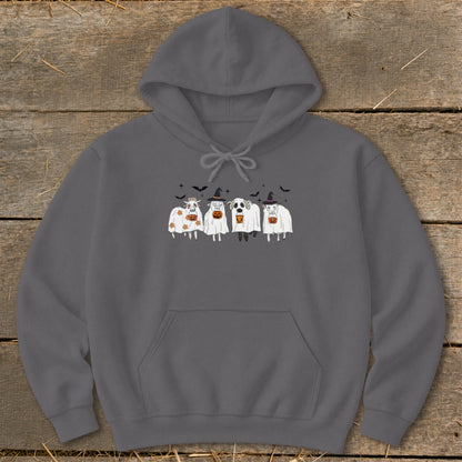 Four cartoon cows dressed as ghosts with pumpkins and bats.