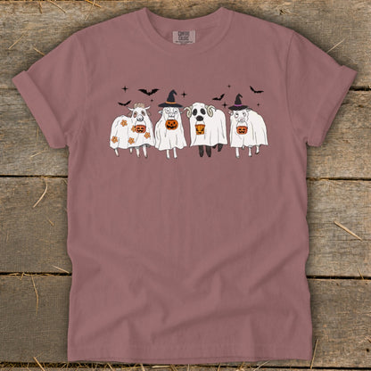 Four sheep dressed as ghosts with pumpkins and bats, on a mauve t-shirt.