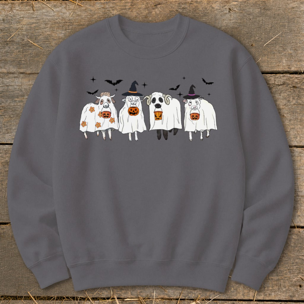 Four sheep dressed as ghosts with pumpkins and witch hats.
