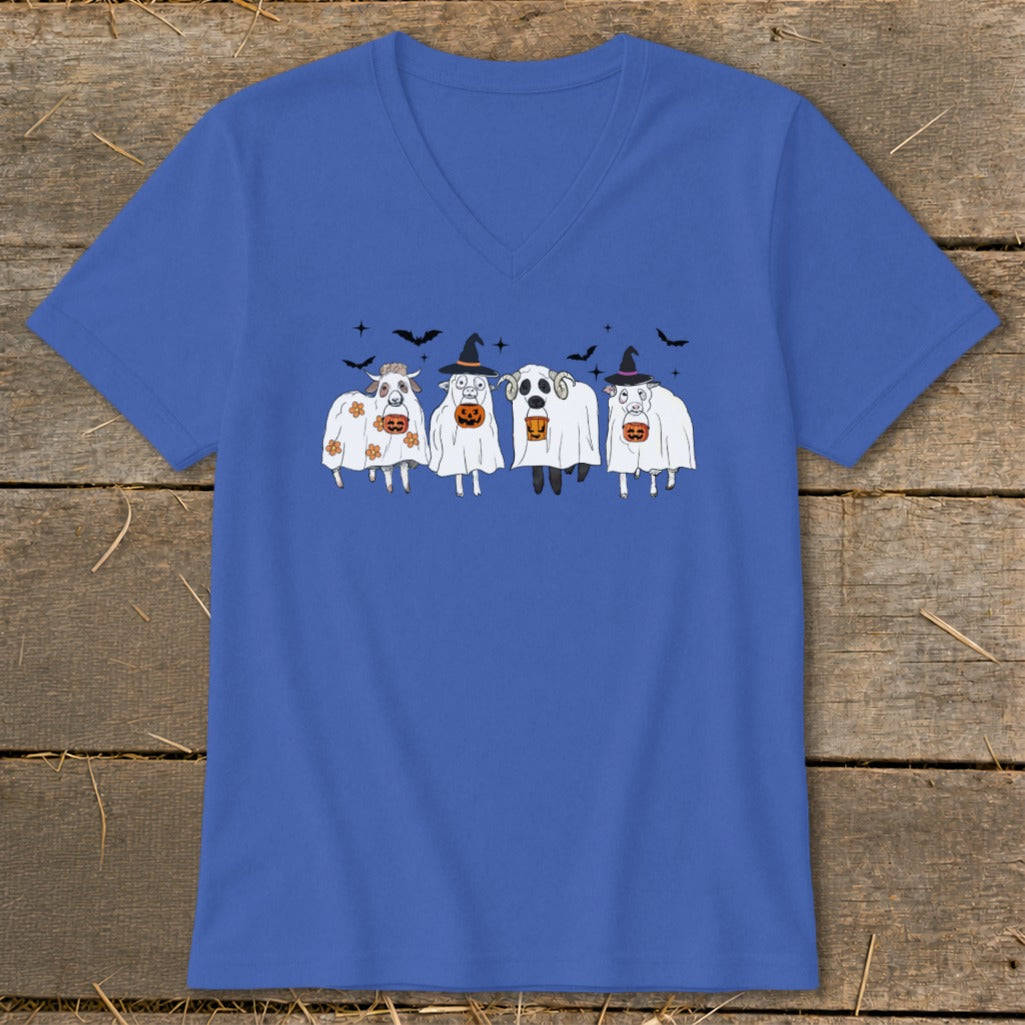 Four cartoon sheep wearing ghost costumes and witch hats with pumpkins.