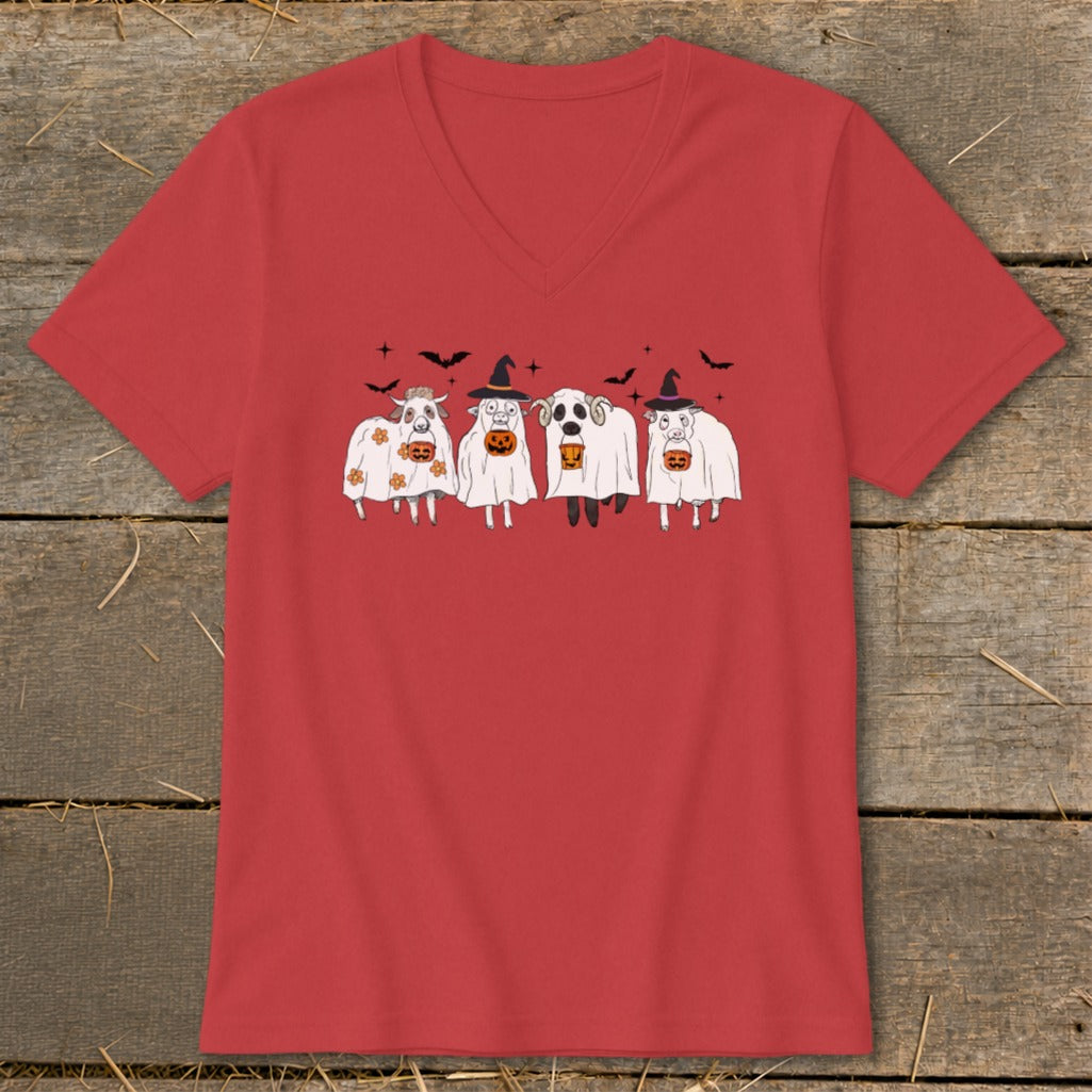 Four cartoon farm animals in Halloween costumes with pumpkins, on a red shirt.
