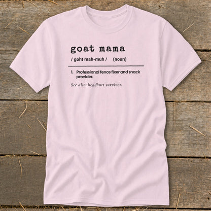 Light pink short-sleeve t-shirt with black dictionary-style text defining goat mama on a wooden background.
