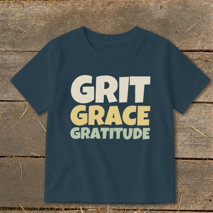 Dark blue short-sleeve children's t-shirt printed with the stacked words Grit, Grace, and Gratitude.