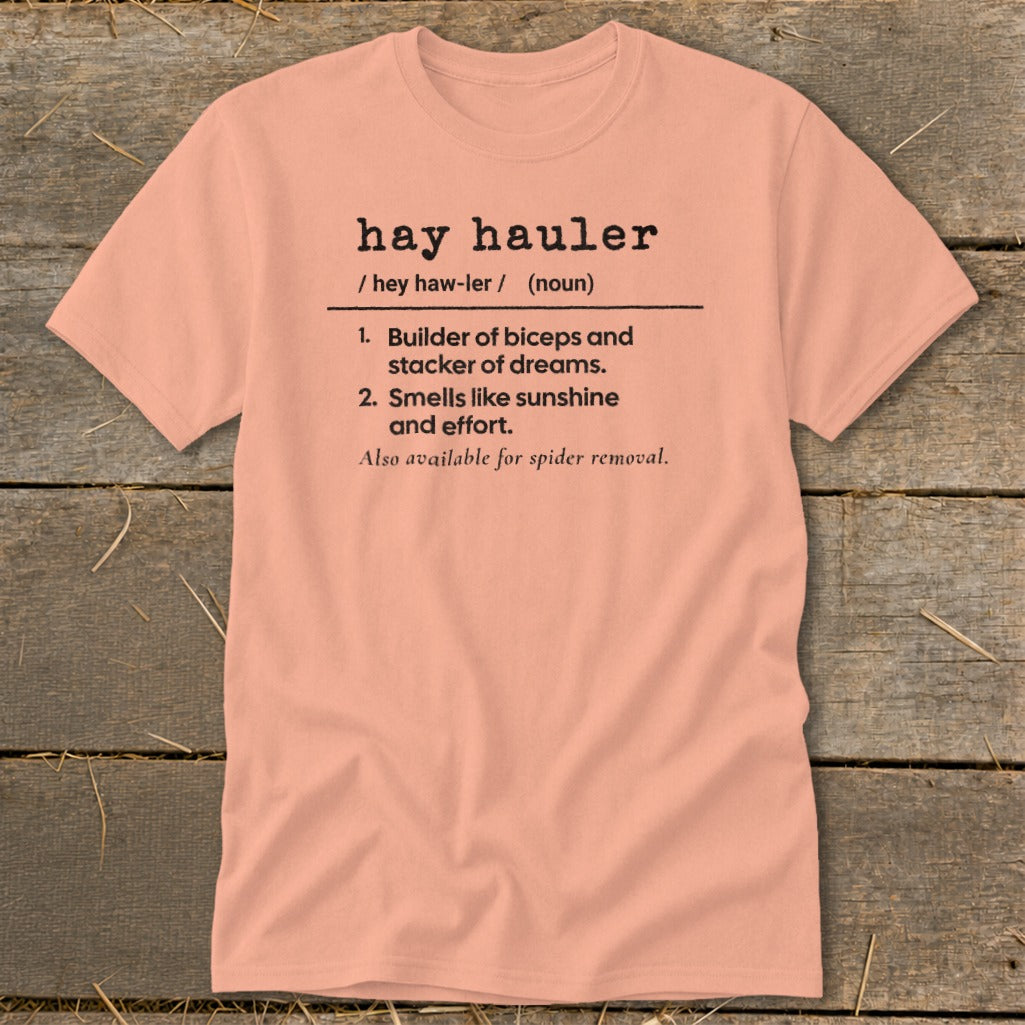 Peach t-shirt with "hay hauler" definition including biceps, dreams, sunshine, effort, and spider removal.