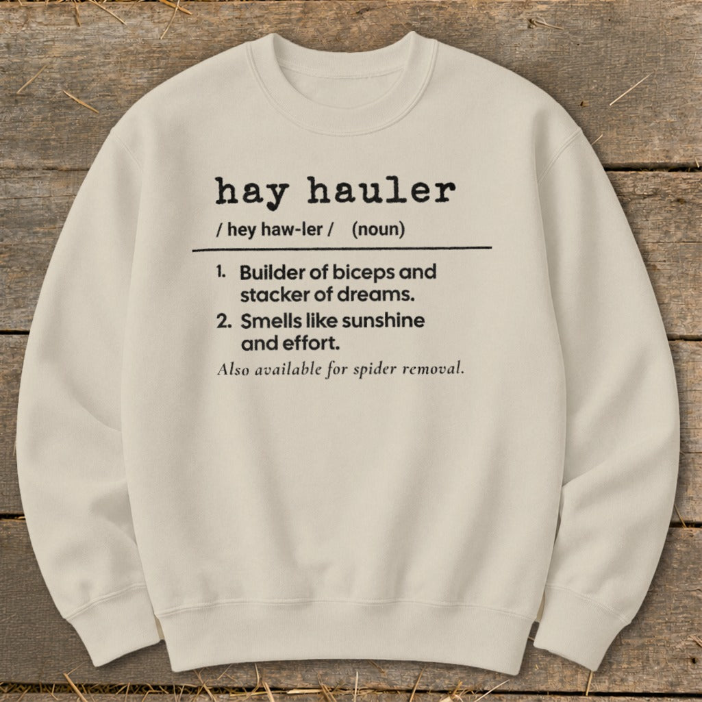 Cream sweatshirt with "hay hauler" definition: builder of biceps, smells like sunshine.