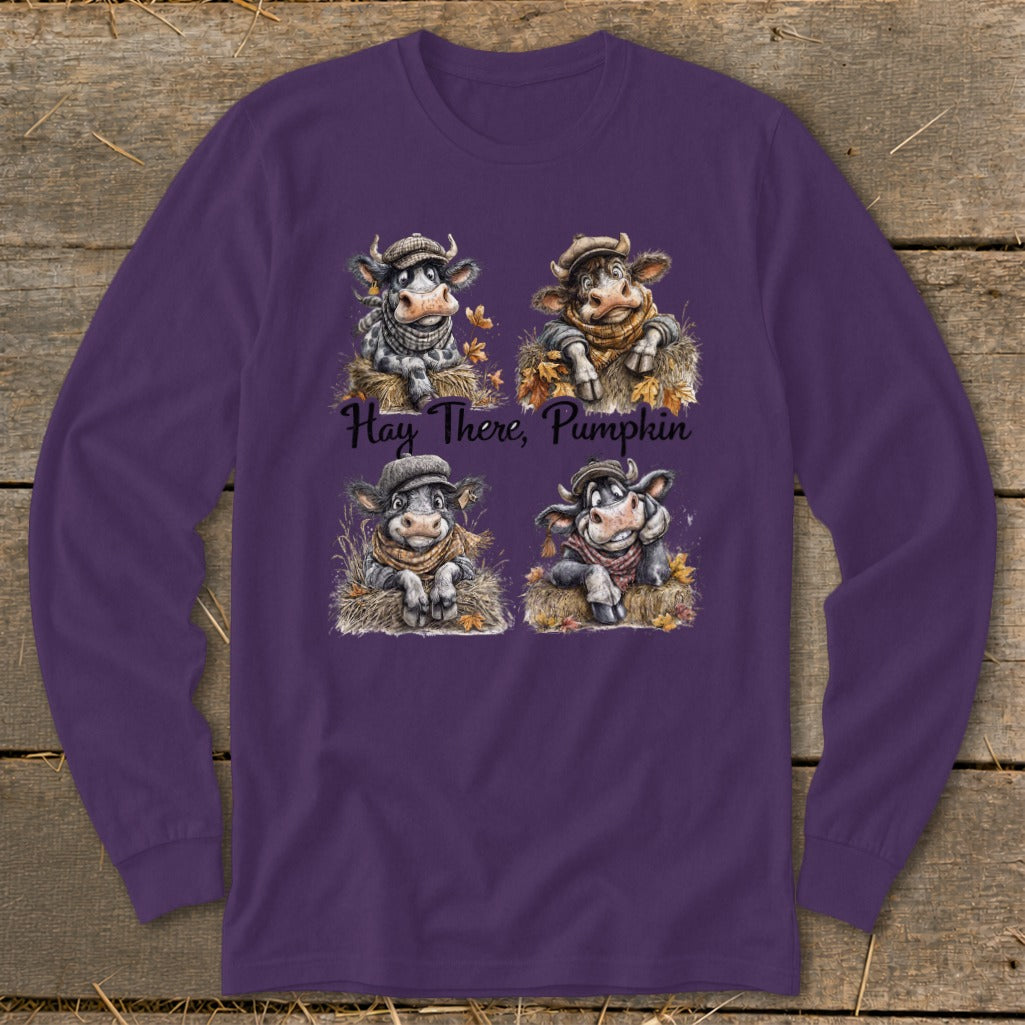 Purple long-sleeved t-shirt featuring a graphic of four cows in autumn hats, with the text Hay There, Pumpkin.