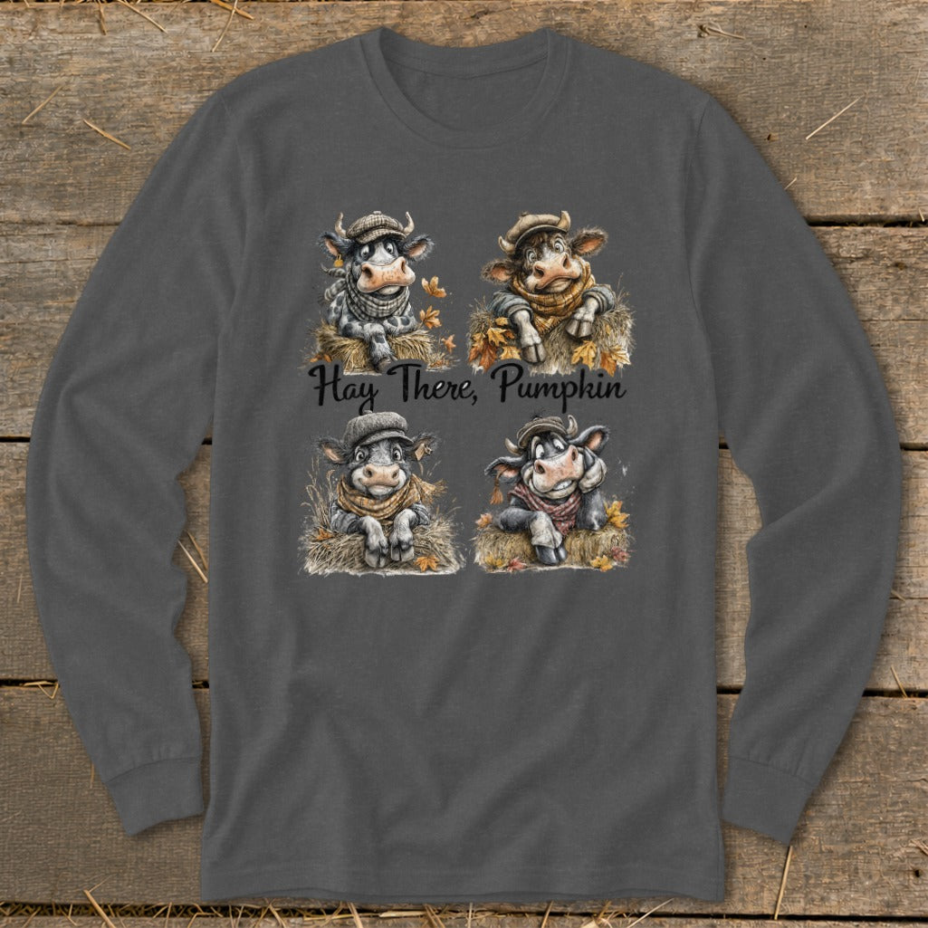 Four cartoon cows wearing scarves and hats sit on hay with autumn leaves; text reads "Hay There, Pumpkin".
