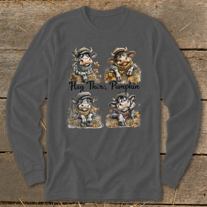 Four cartoon cows wearing scarves and hats sit on hay with autumn leaves; text reads "Hay There, Pumpkin".
