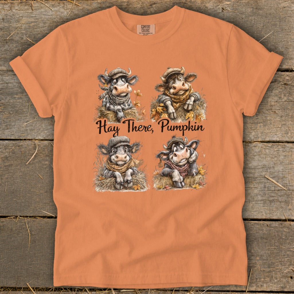 Orange t-shirt with four cartoon cows and the text "Hay There, Pumpkin."