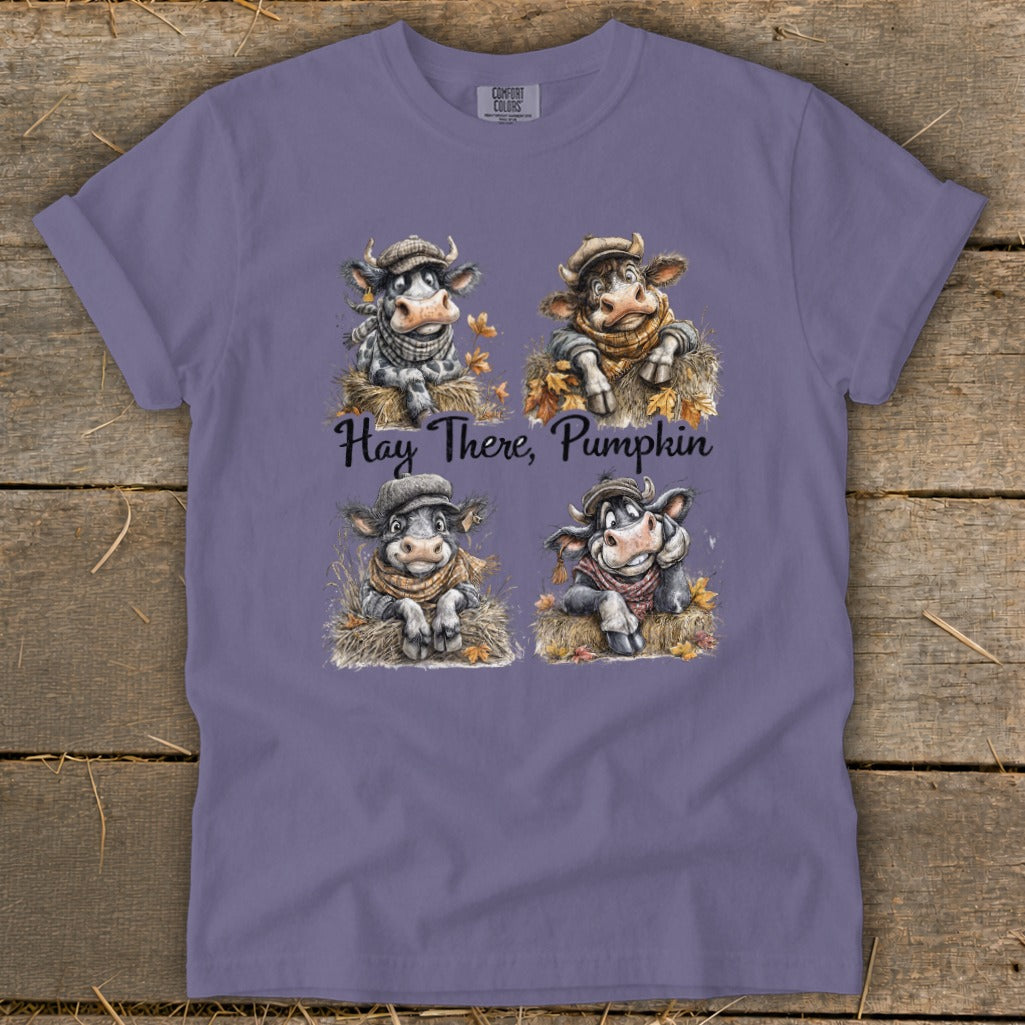 Four cartoon cows wearing scarves and hats sit in hay, with the text "Hay There, Pumpkin."