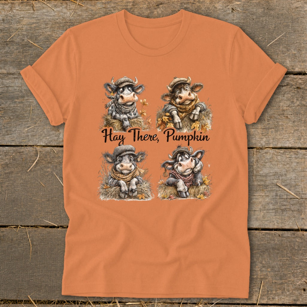 Orange t-shirt with four illustrated cows and "Hay There, Pumpkin" text.