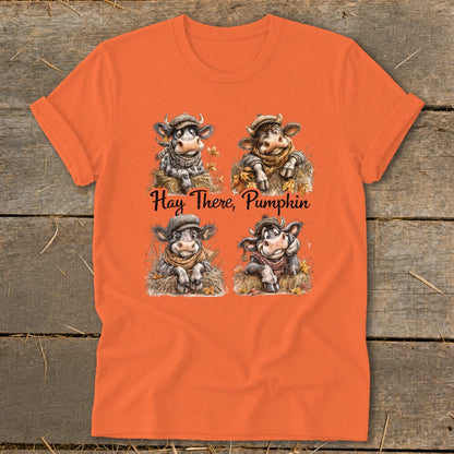 Orange t-shirt with four illustrated cows wearing scarves and hats with "Hay There, Pumpkin" text.