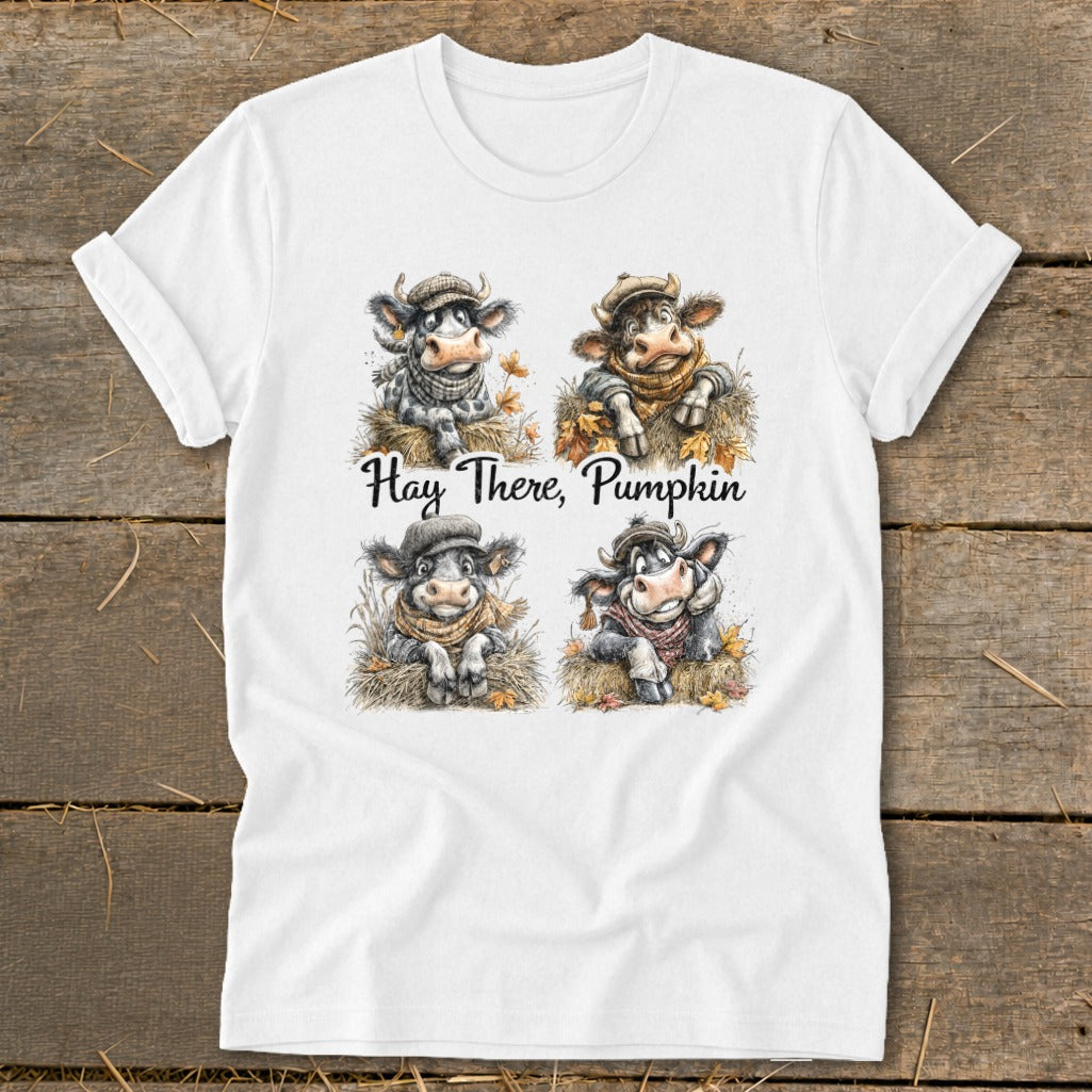 Four illustrated cows wearing scarves and hats sit in hay with autumn leaves. "Hay There, Pumpkin" is written below.