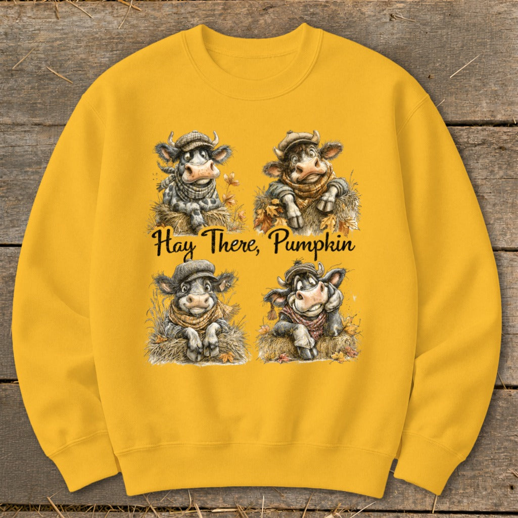 Four cartoon cows with scarves and hats sit in hay with the text "Hay There, Pumpkin."