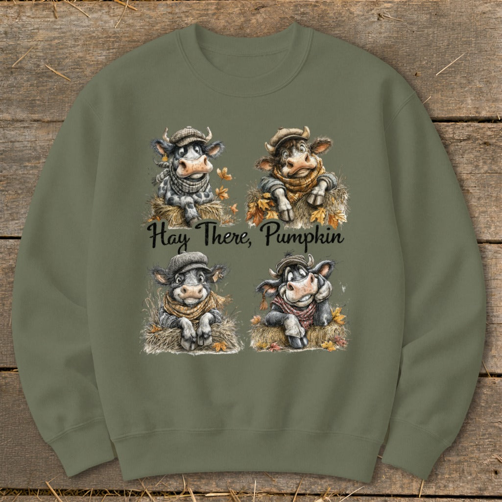 Four cartoon cows wearing hats and scarves on hay bales with the text "Hay There, Pumpkin".