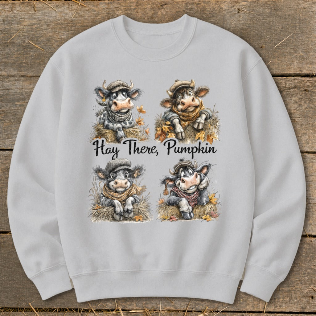 Crewneck sweatshirt with four cartoon cows in hats and scarves, text says "Hay There, Pumpkin."