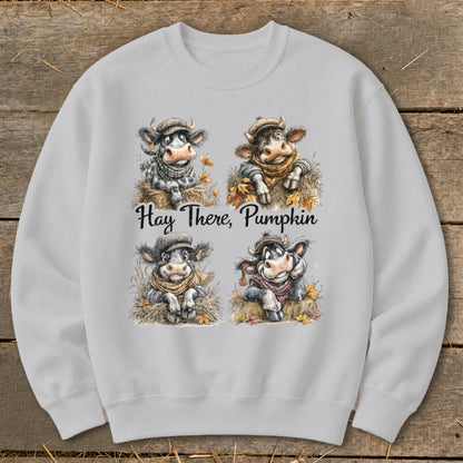 Crewneck sweatshirt with four cartoon cows in hats and scarves, text says "Hay There, Pumpkin."