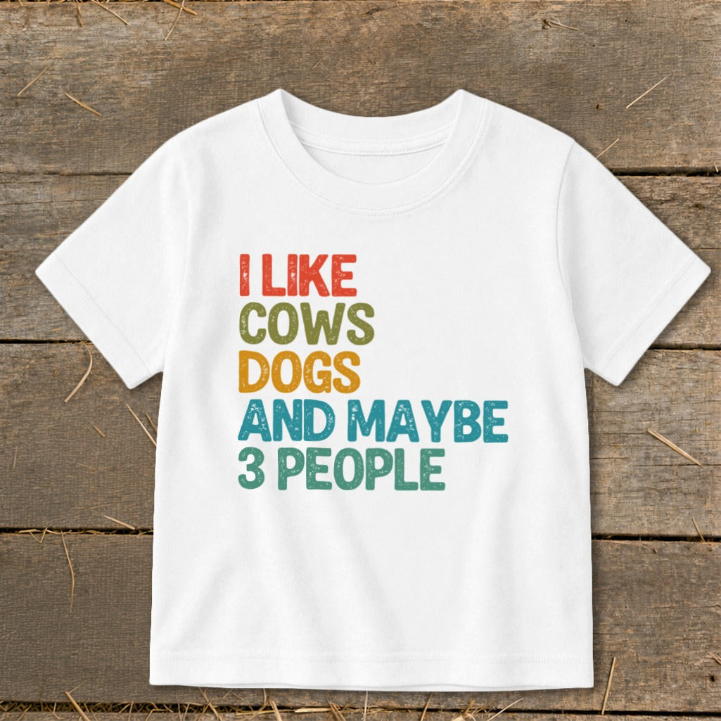 White t-shirt with colorful text: "I LIKE COWS DOGS AND MAYBE 3 PEOPLE"