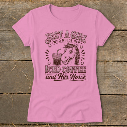 Pink women's t-shirt printed with a horse graphic, an iced coffee cup, and text reading Just A Girl Who Needs Her Iced Coffee and Her Horse.