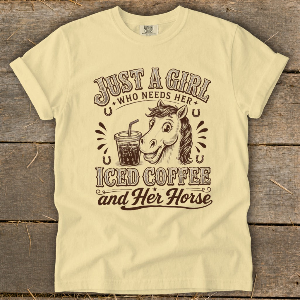 Light yellow t-shirt with a brown graphic of a horse, iced coffee, and text saying Just a girl who needs her iced coffee and her horse.