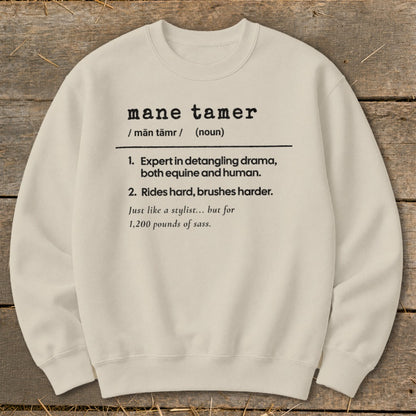 Cream sweatshirt with "mane tamer" definition, referencing equine and human drama.