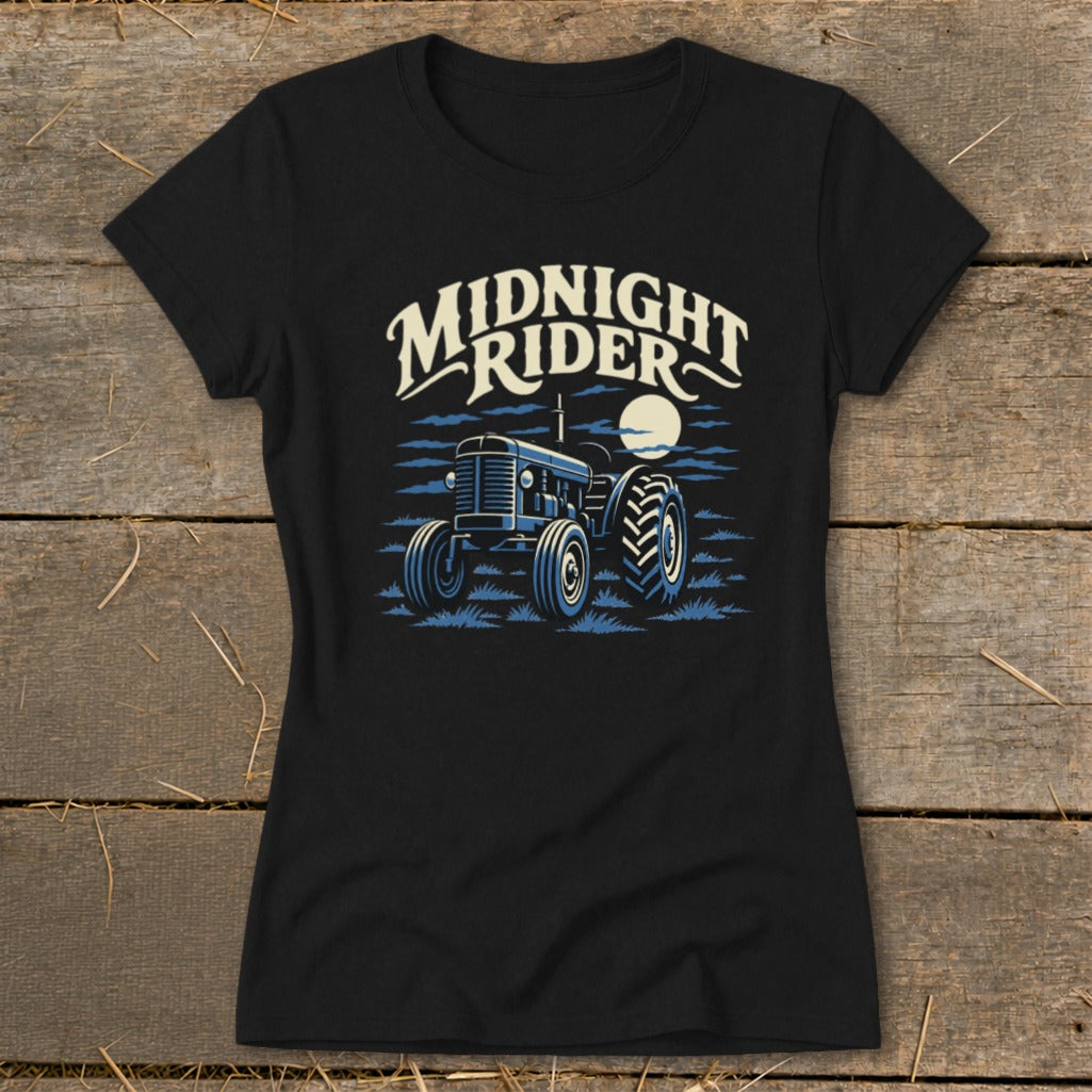 A black short-sleeved t-shirt featuring a blue tractor illustration, a moon, and the text Midnight Rider.