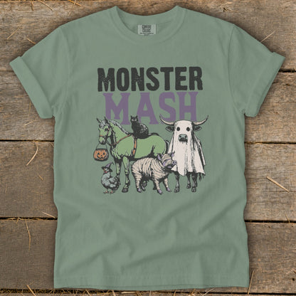 A sage green t-shirt displays a vintage Halloween design with farm animals and text reading MONSTER MASH.