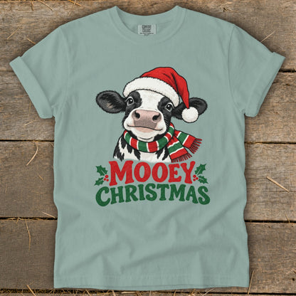T-shirt with a cartoon cow wearing a Santa hat and striped scarf, text says "Mooey Christmas."