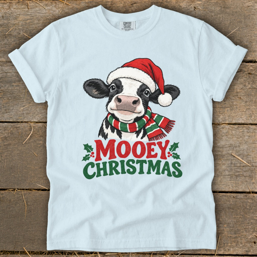 Light blue t-shirt with a cow wearing a Santa hat and striped scarf, saying "Mooey Christmas".