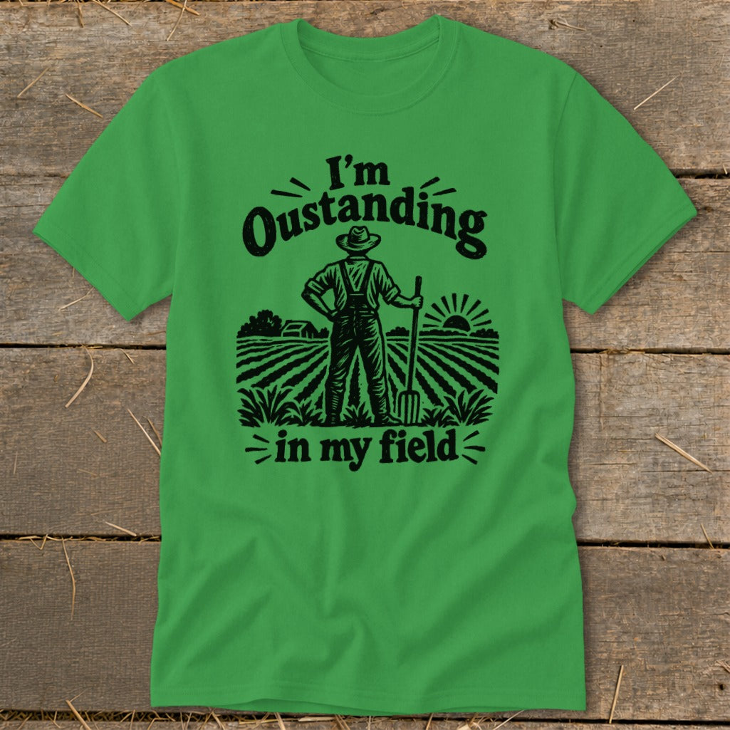 Green t-shirt with black graphic of a farmer in a field saying "I'm Oustanding in my field".