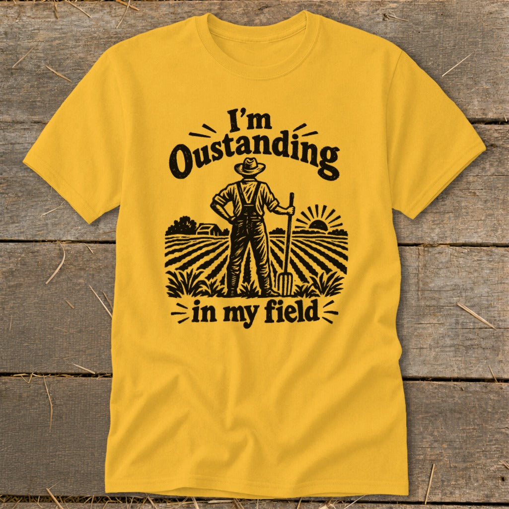 Yellow t-shirt with black graphic of a farmer in a field with text "I'm Oustanding in my field".