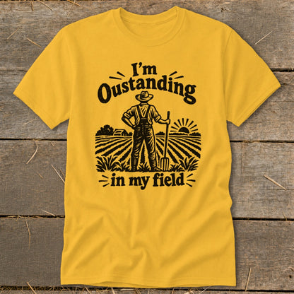 Yellow t-shirt with black graphic of a farmer in a field with text "I'm Oustanding in my field".