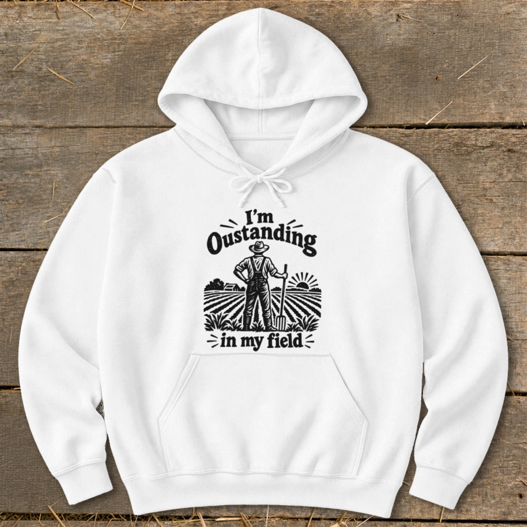 A white hooded sweatshirt featuring a black graphic of a farmer in a field with text that reads I'm Oustanding in my field.